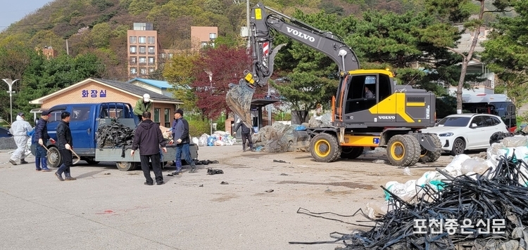 신원식 통장외 4명이 수거 운반된 폐기물을 내리는 작업을 하고 있다. 