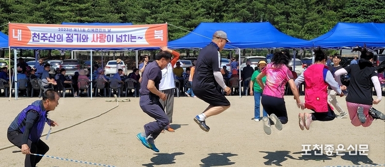 내북팀 6명이 한마음이 되어 줄넘기하는 가운데 경기 모습 뒤로는 내북팀의 먹거리 장이 펼쳐있다.