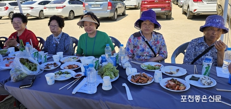마을에서 준비한 떡, 고기 등의 한 상 받으신 어르신들이 심판보는 표정으로 경기를 감상하고 있다.