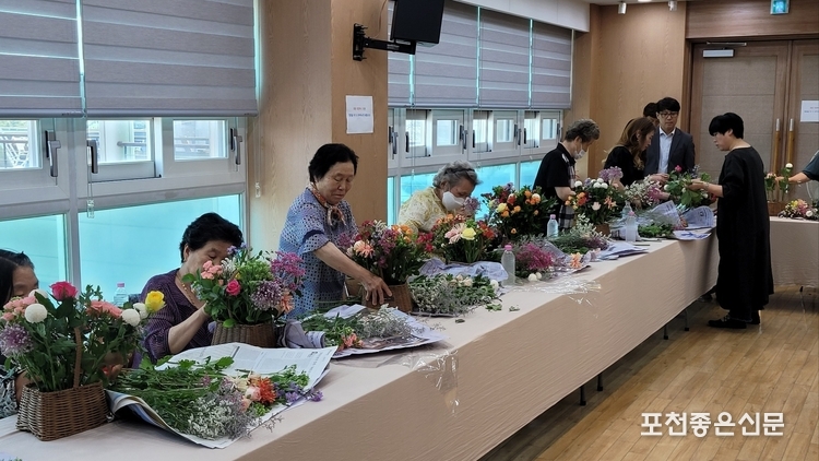 어르신들이 한 송이마다 정성을 담아 꽃바구니를 만들고 있다.