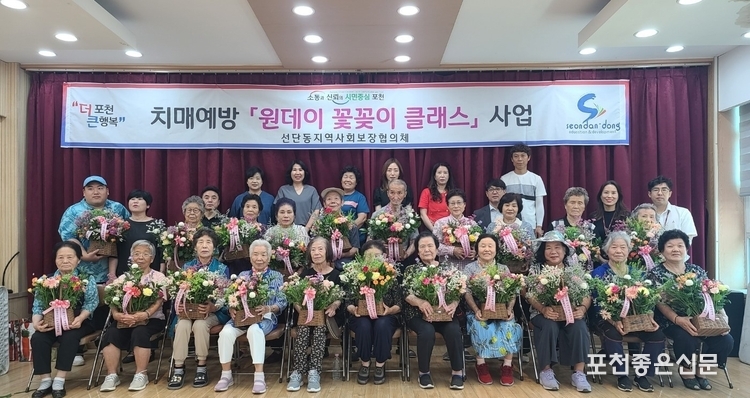어르신들이 직접 만든 꽃바구니를 품에 안고 평화로운 표정으로 기념 촬영을 하고 있다. 