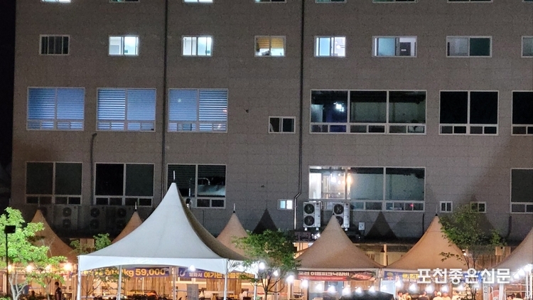 가림막 사이로 반주시설과 조명시설을 갖춘 왼쪽 2층 건물이 보인다. 
