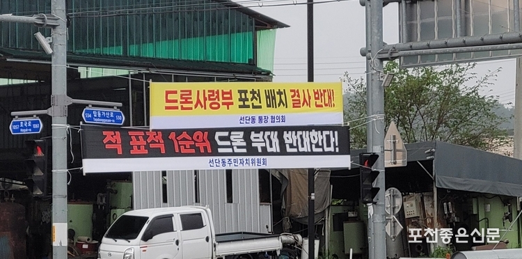 광암마산 간 도로의 선단동 사거리에 '드론사령부' 배치 결사반대 문구의 선단동 통장협의회, 주민자치위원회 플래카드가 걸려 있다.