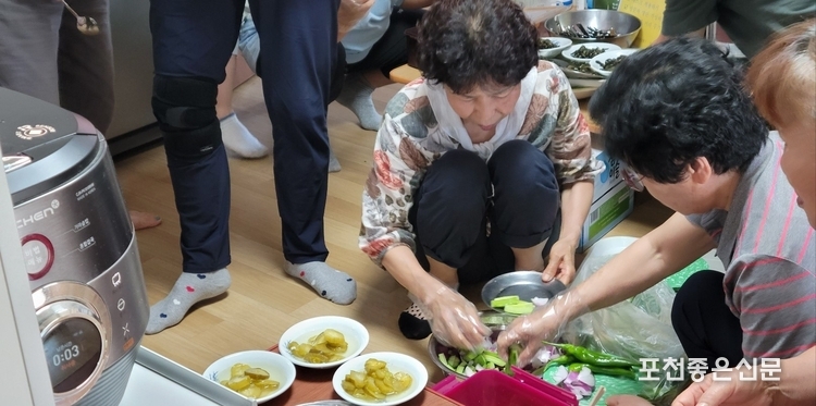 부녀회원이 마련한 음식과 반찬을 그릇에 담고 있다. 