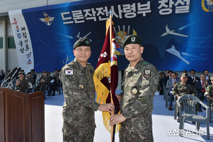 드론작전사령부 창설식에서 김승겸 합참의장(왼쪽)이 초대 드론작전사령관 이보형 소장(오른쪽)에게 부대기를 수여하고 있다.