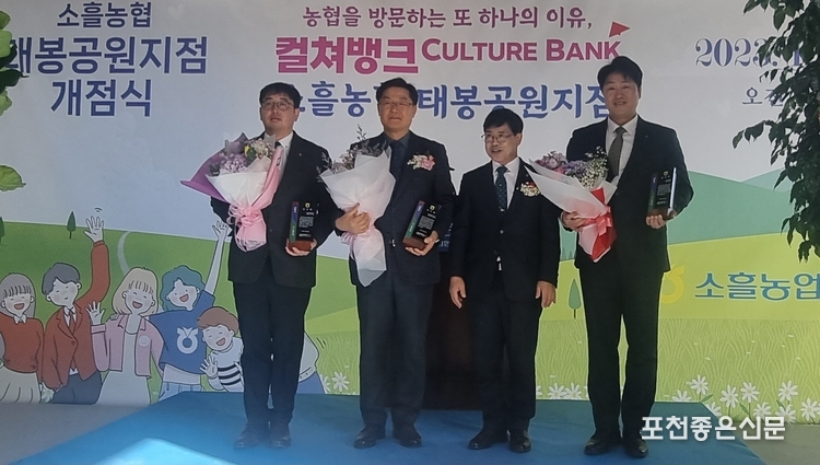 김재원 조합장이 태봉공원 지점 개점에 수고를 아끼지 않은 직원들에게 표창하고 사진촬영하고 있다.