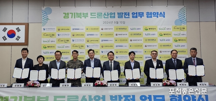 서명한 협약서를 들어보이고 있다.