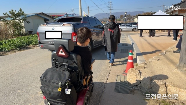 휠체어가 차도로 위험하게 이동하고 있다.